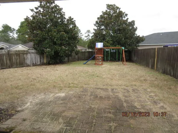 a backyard of a house with table and chairs