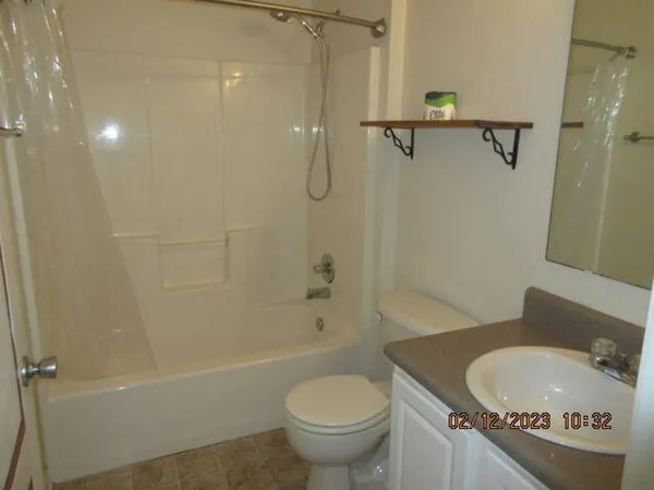 a bathroom with a granite countertop toilet a sink and bathtub