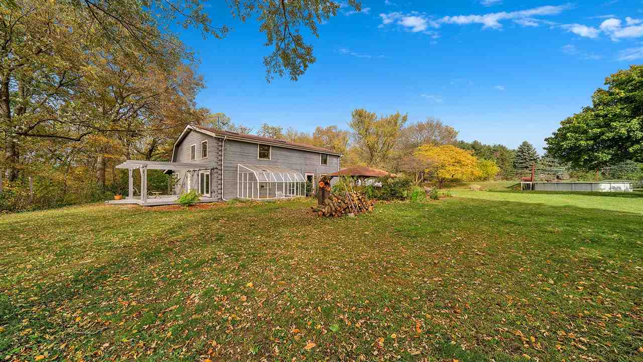 6315 North River Road Byron, IL 61010 - Photo 35 of 40 a yellow house with garden in front of it