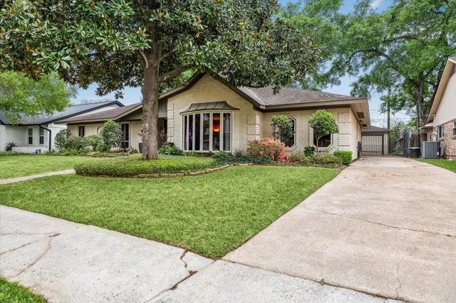 a front view of a house with a yard and trees