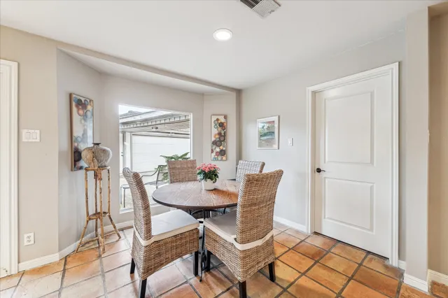 a kitchen with a table chairs refrigerator and microwave