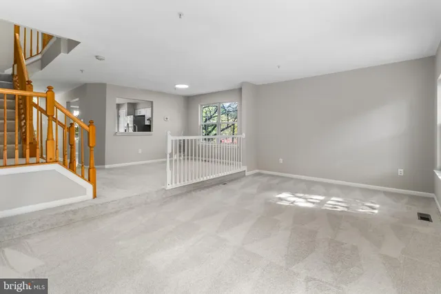 a view of a livingroom with wooden floor and stairs