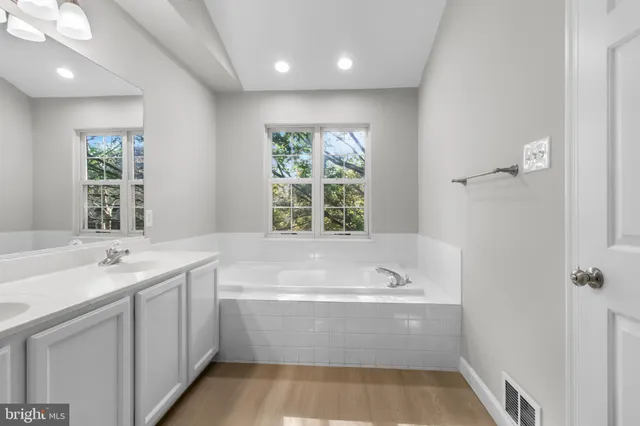 a bathroom with a bathtub a sink and a window