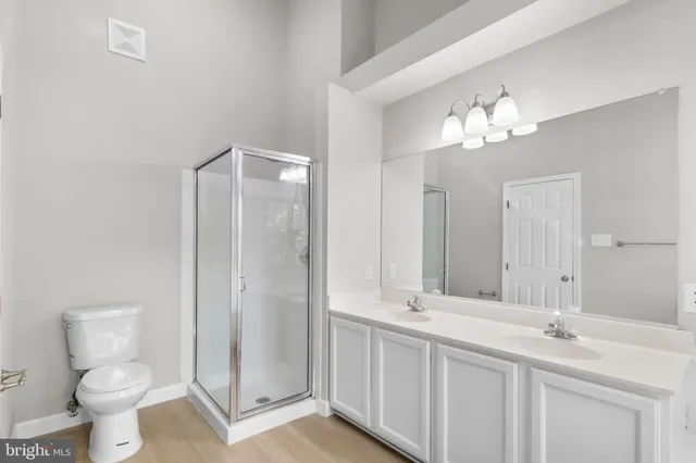 a bathroom with a double vanity sink toilet and a mirror