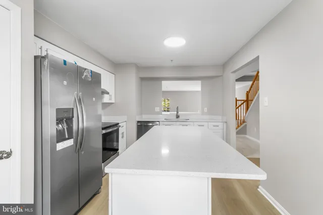 a kitchen with a refrigerator sink and cabinets