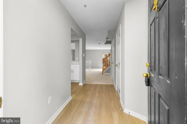 a view of a hallway with wooden floor and staircase