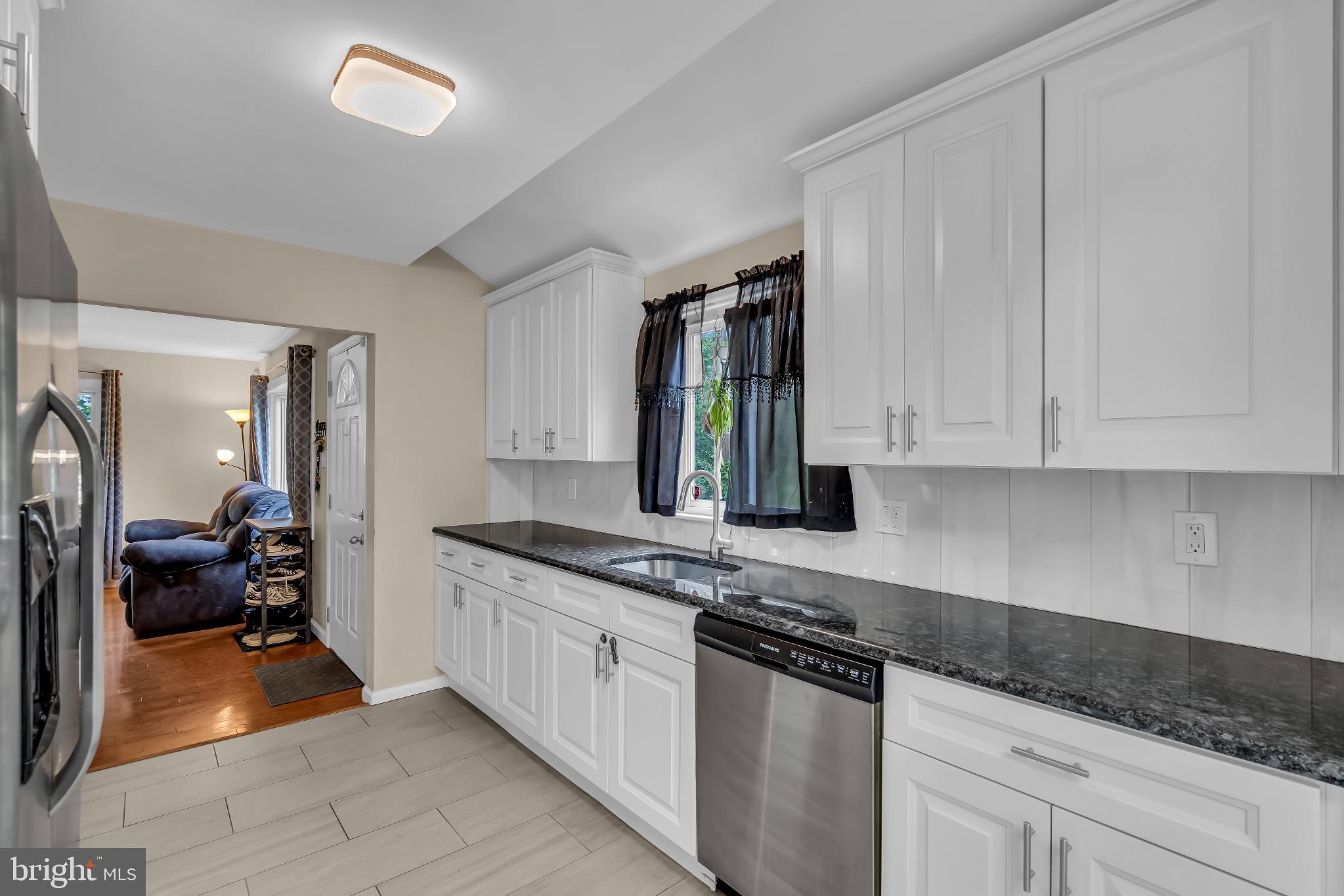 2002 South Brighton Avenue Clementon, NJ 08021 - Photo 15 of 38 a kitchen with granite countertop a sink stainless steel appliances white cabinets and a window