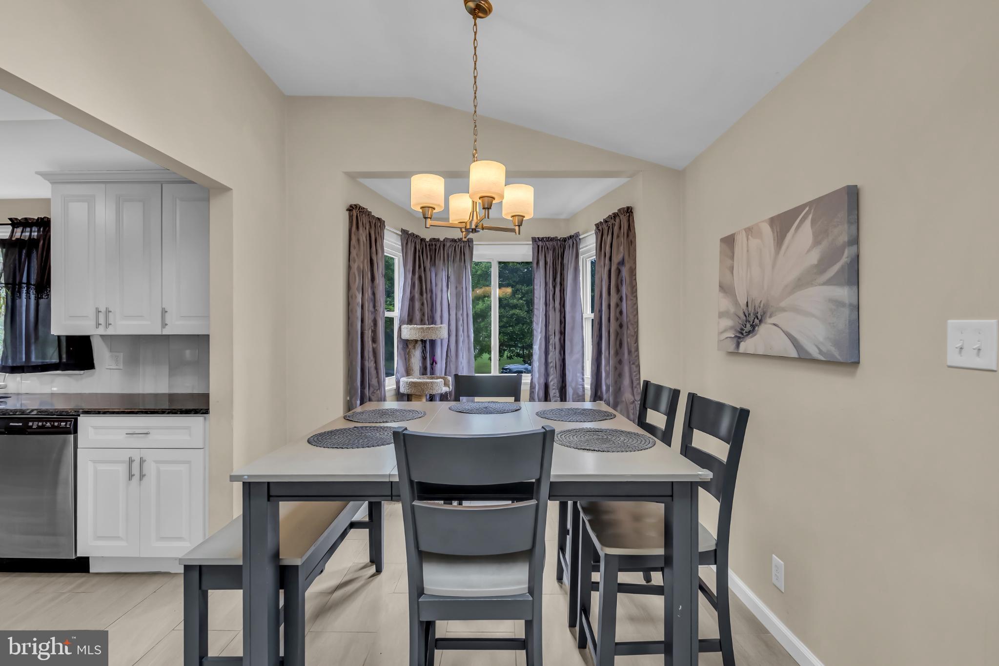 2002 South Brighton Avenue Clementon, NJ 08021 - Photo 21 of 38 a dining room with wooden floor a chandelier a wooden table and chairs