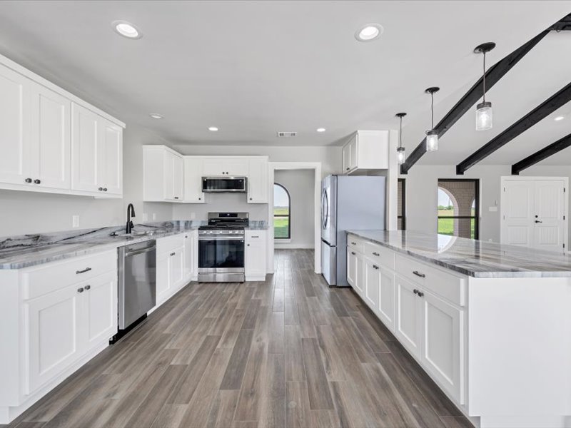2719 Post Oak Road Webberville, TX 78653 - Photo 7 of 23 a large kitchen with granite countertop a large counter top a sink stainless steel appliances and cabinets