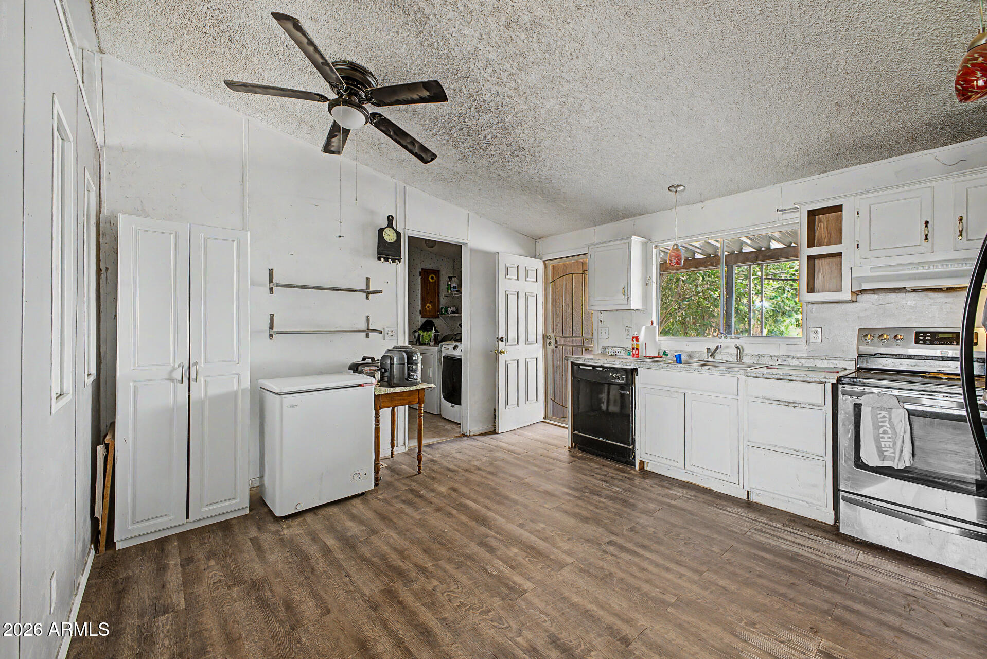 8595 North Palo Verde Road Florence, AZ 85132 - Photo 11 of 41 a kitchen with a refrigerator cabinets and wooden floor