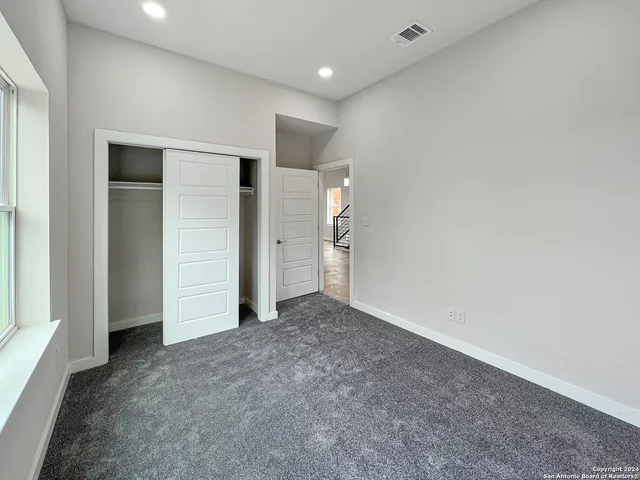an empty room with closet and mirror