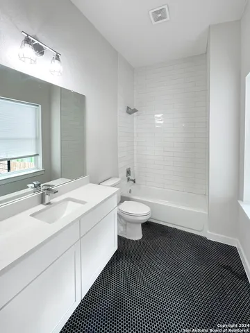 a bathroom with a double vanity sink toilet and a mirror