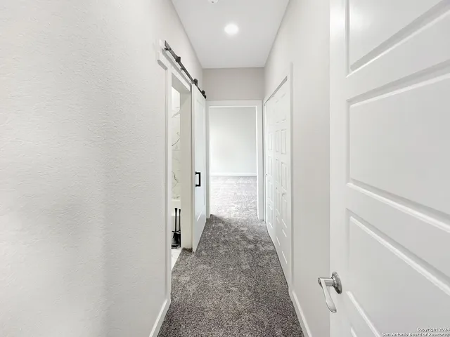 a view of a hallway with a white walls and a white door