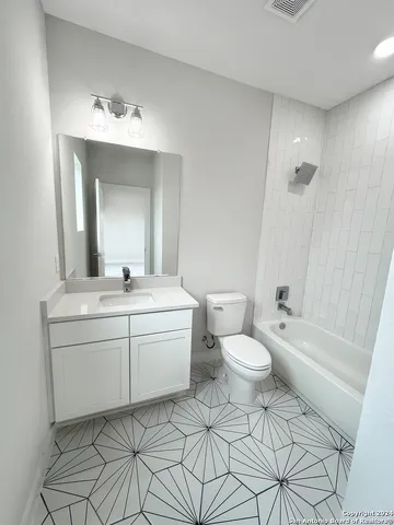 a bathroom with a toilet a sink a mirror and bathtub
