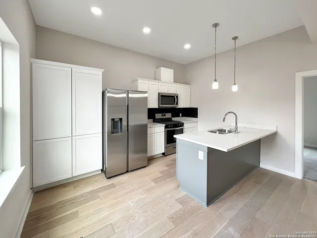 a kitchen with a sink refrigerator and microwave