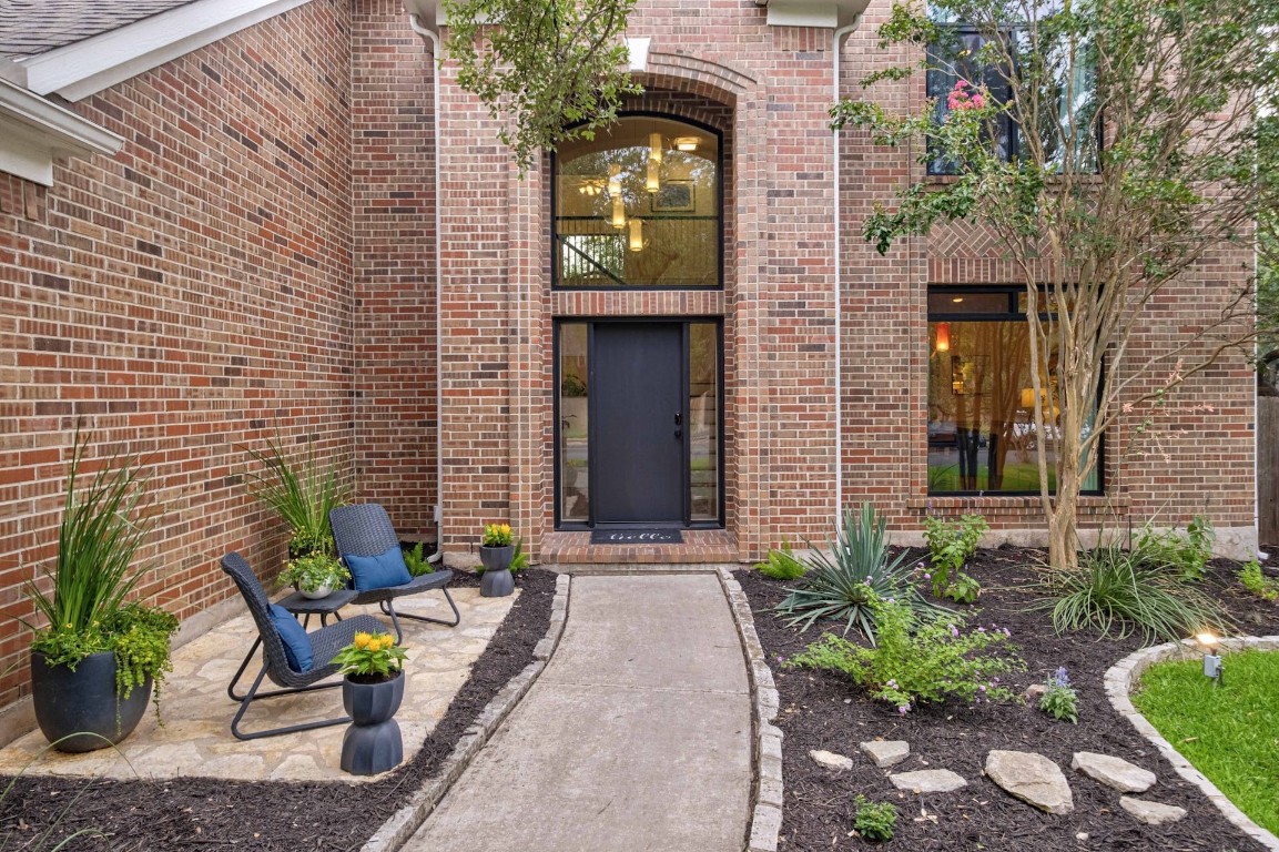 a view of a brick house with potted plants