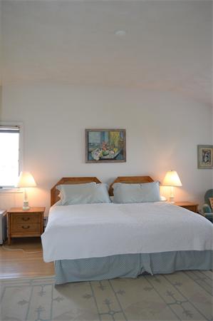 155 Sakonnet Point Road Little Compton, RI 02837 - Photo 10 of 15 a bedroom with a bed and a lamp