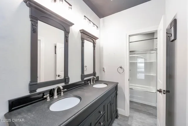 a bathroom with a double vanity sink and a mirror
