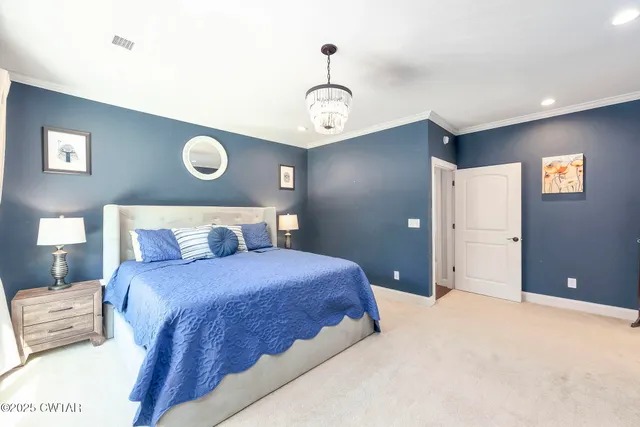 a bedroom with a bed and a chandelier