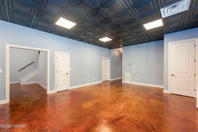 a front view of a house with a yard fire pit and trees in the background