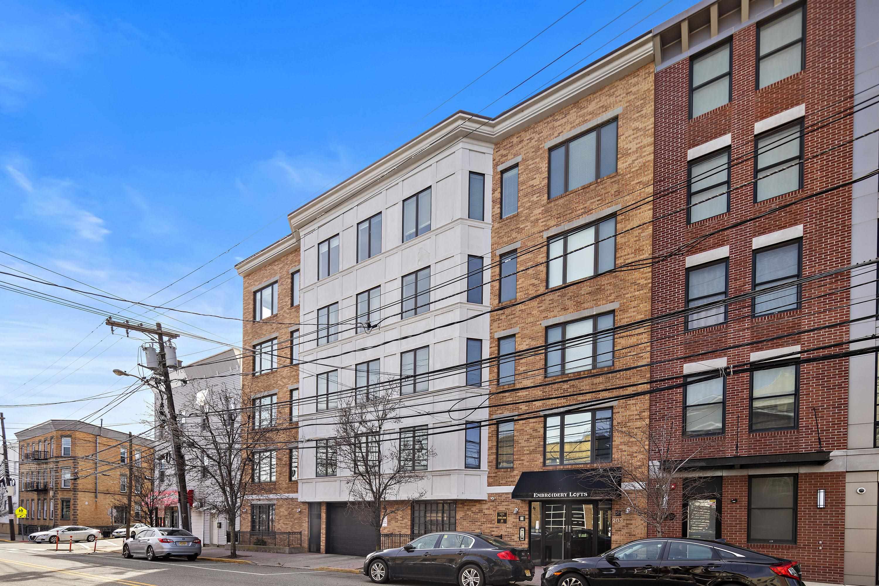 203-207 Hackensack Plank Road, Unit 4B Weehawken, NJ 07086 - Photo 25 of 27 a front view of a building with lot of cars and trees
