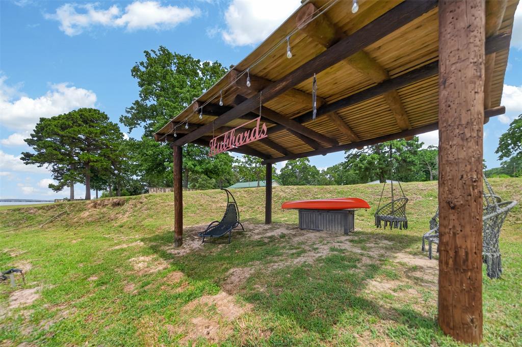 23363 Wateridge Loop Flint, TX 75762 - Photo 15 of 40 a view of a backyard with table and chairs under an umbrella