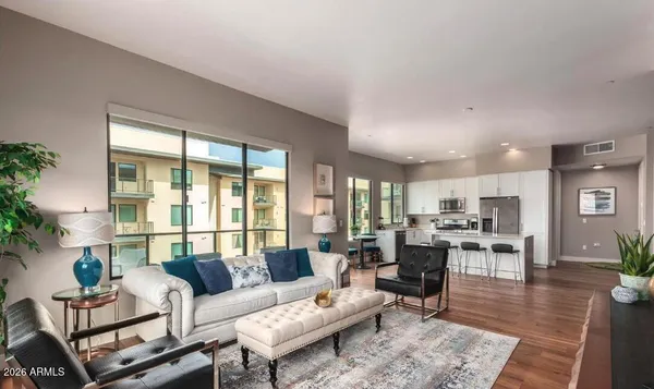 a living room with furniture wooden floor and a large window