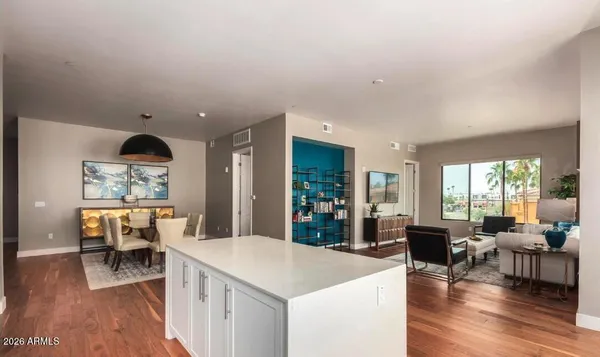 a large kitchen with a large window and wooden floor