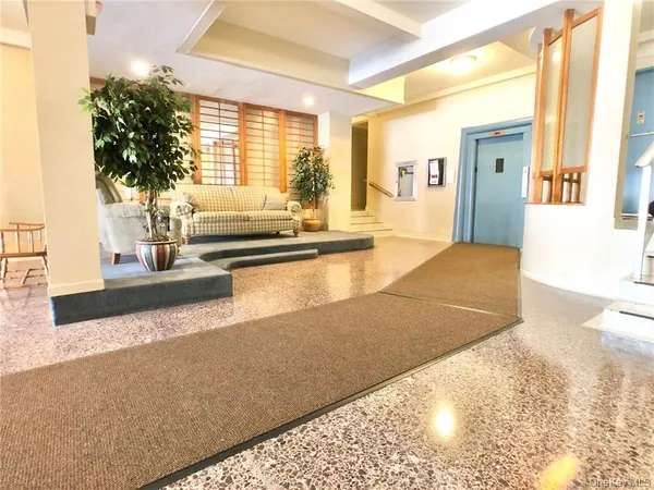 a view of a living room with kitchen floor and large windows