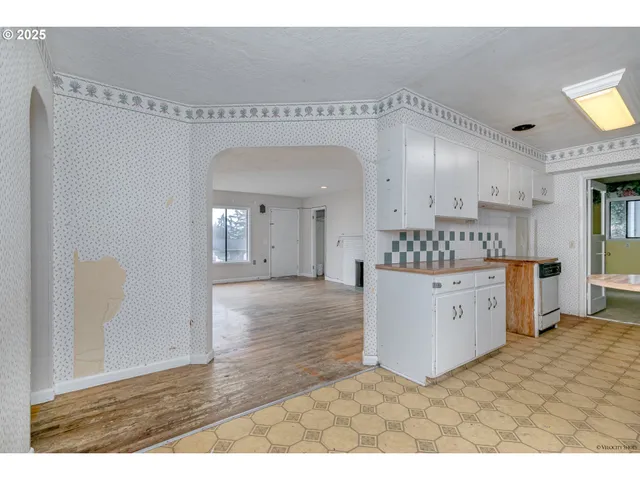 a kitchen with cabinets and wooden floor