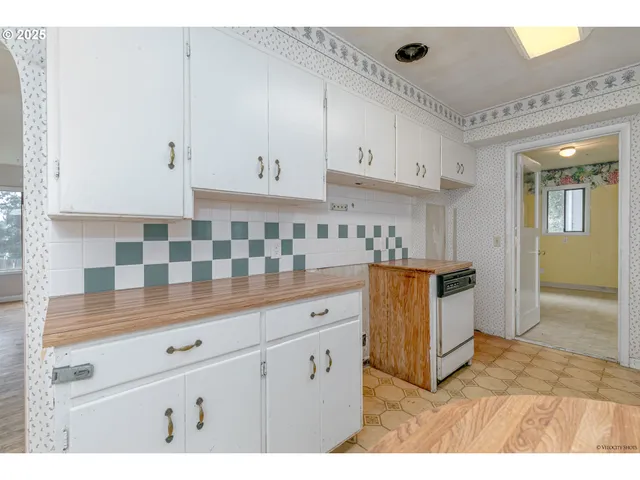 a kitchen with granite countertop white cabinets and stainless steel appliances