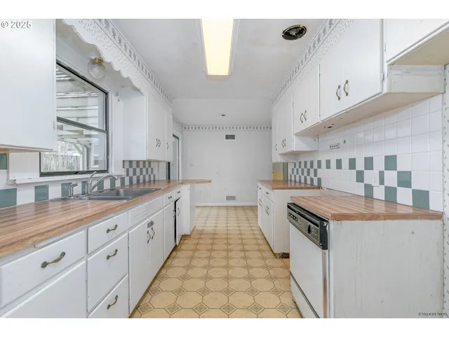 a kitchen with granite countertop a sink stove and cabinets