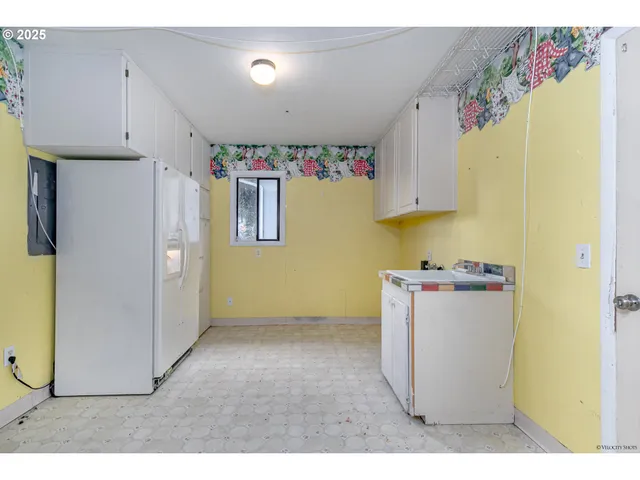 a utility room with a refrigerator and a car
