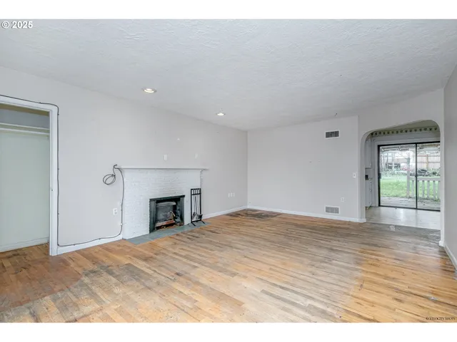 a view of empty room with window and fireplace