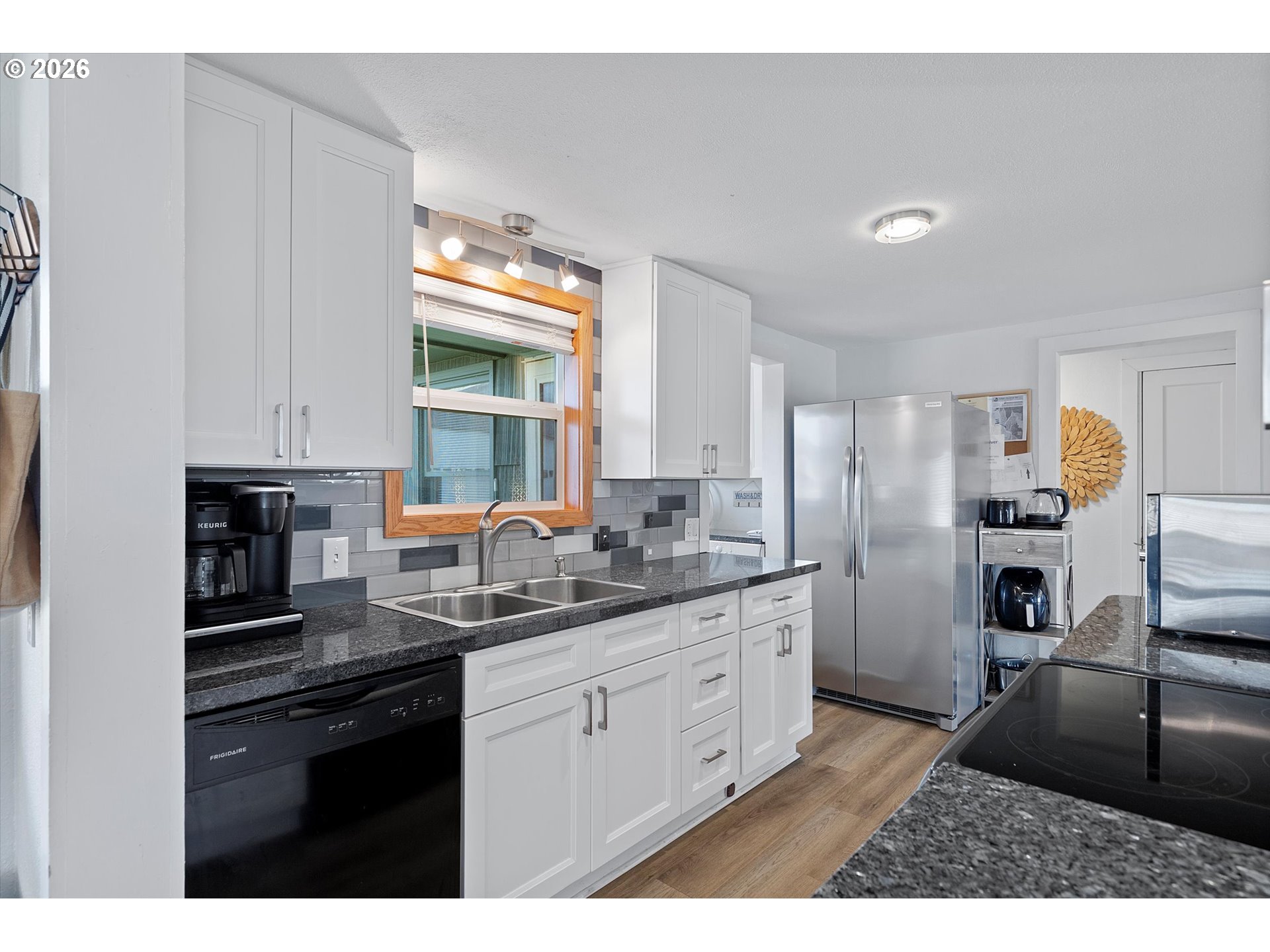 35160 Rueppel Avenue Pacific City, OR 97135 - Photo 13 of 34 a kitchen with stainless steel appliances kitchen island granite countertop a refrigerator a sink a stove and white cabinets