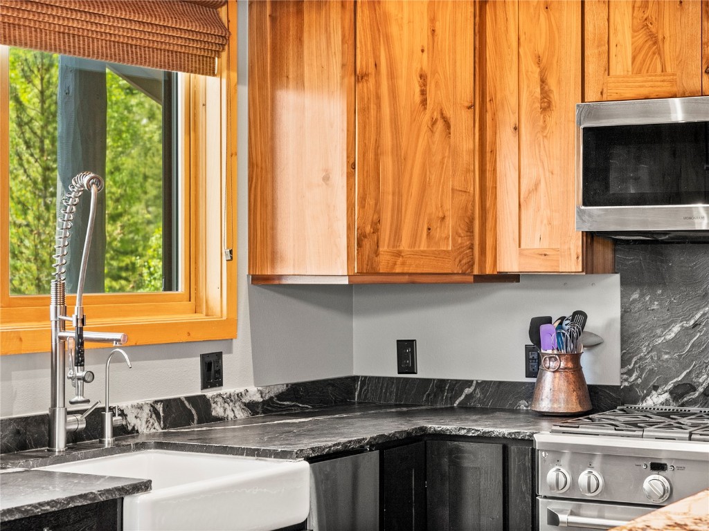 89 Emerald Road Silverthorne, CO 80498 - Photo 13 of 46 a kitchen with granite countertop a stove a sink and a microwave