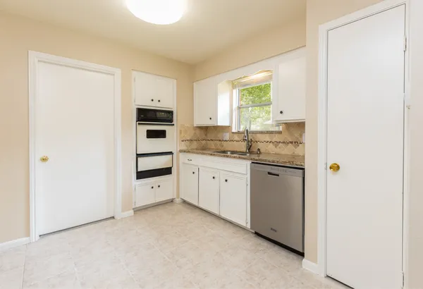a kitchen with white cabinets and white appliances