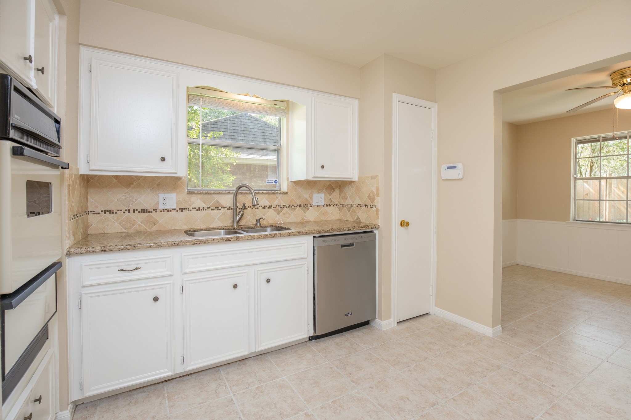 2623 Longleaf Pines Lane Houston, TX 77339 - Photo 15 of 32 a kitchen with granite countertop white cabinets sink and window