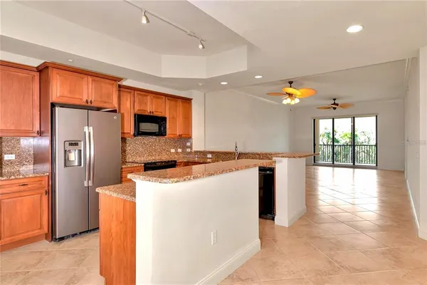 a kitchen with stainless steel appliances granite countertop a refrigerator a sink and a stove