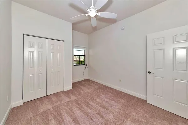 an empty room with closet and windows