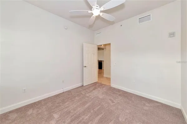 an empty room with fan and entryway