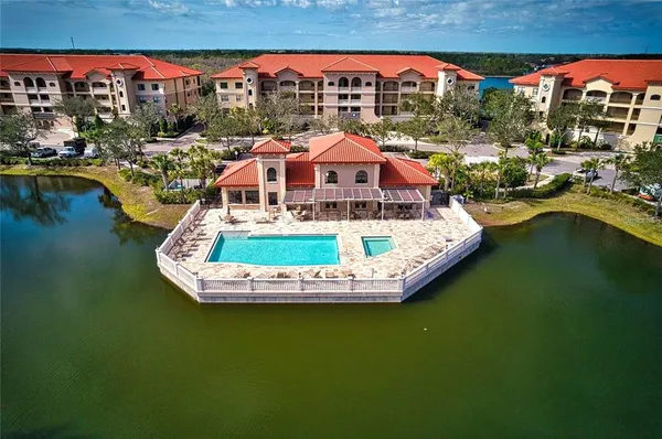 a view of a house with pool outdoor seating and lake view