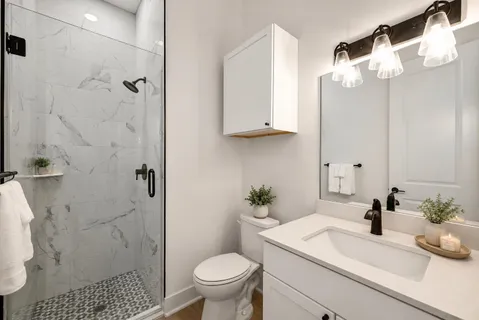 a bathroom with a sink a toilet and shower