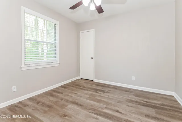 wooden floor in an empty room with a window