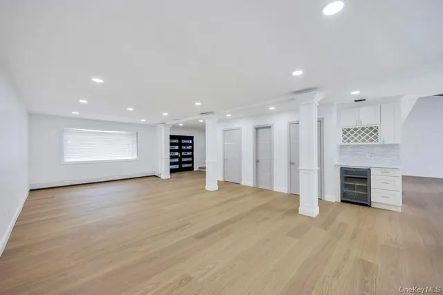 an empty room with wooden floor and natural light