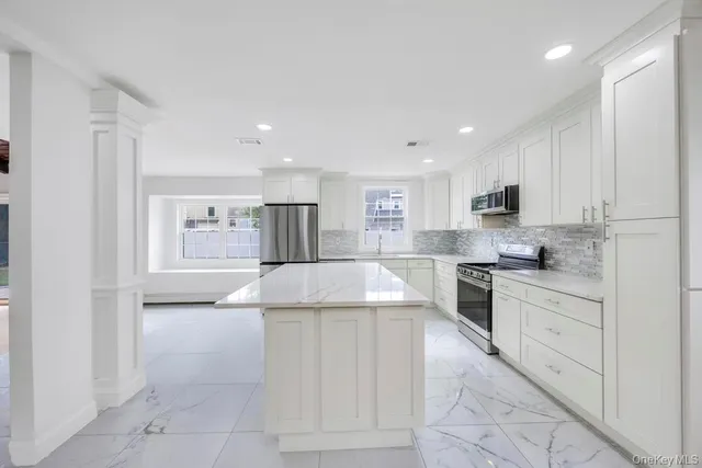 a kitchen with a refrigerator sink and cabinets