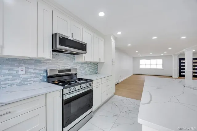 a kitchen with white cabinets and stainless steel appliances
