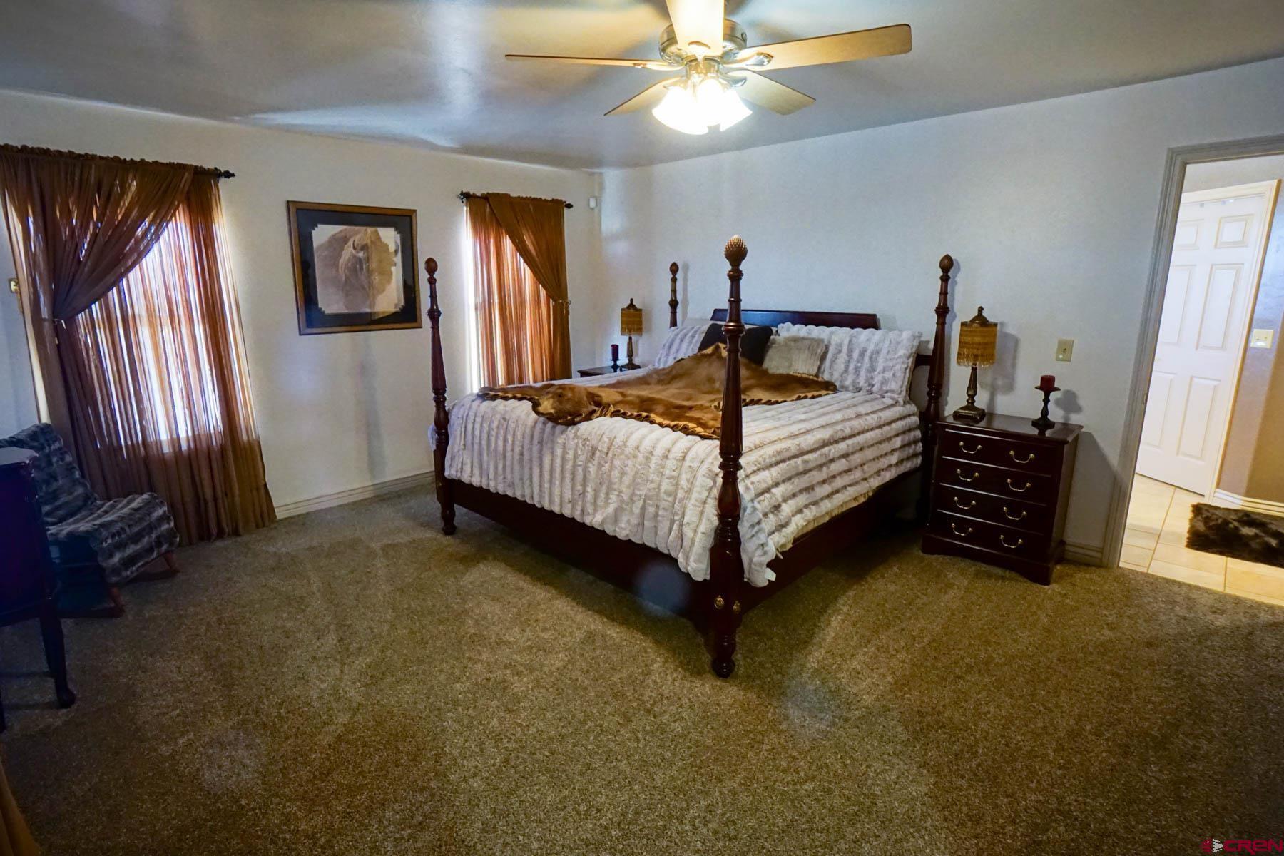 16575 2550th Road Cedaredge, CO 81413 - Photo 12 of 32 a bedroom with a bed and a chandelier