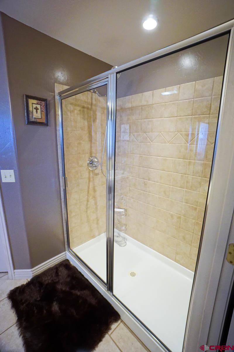 16575 2550th Road Cedaredge, CO 81413 - Photo 13 of 32 a bathroom with a glass shower door and a bathtub
