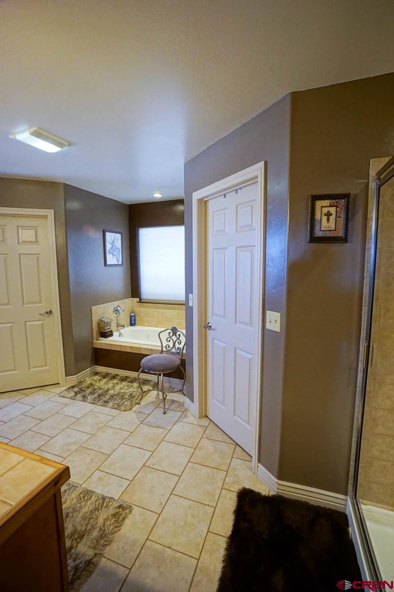16575 2550th Road Cedaredge, CO 81413 - Photo 14 of 32 a bedroom with a bed and a dresser